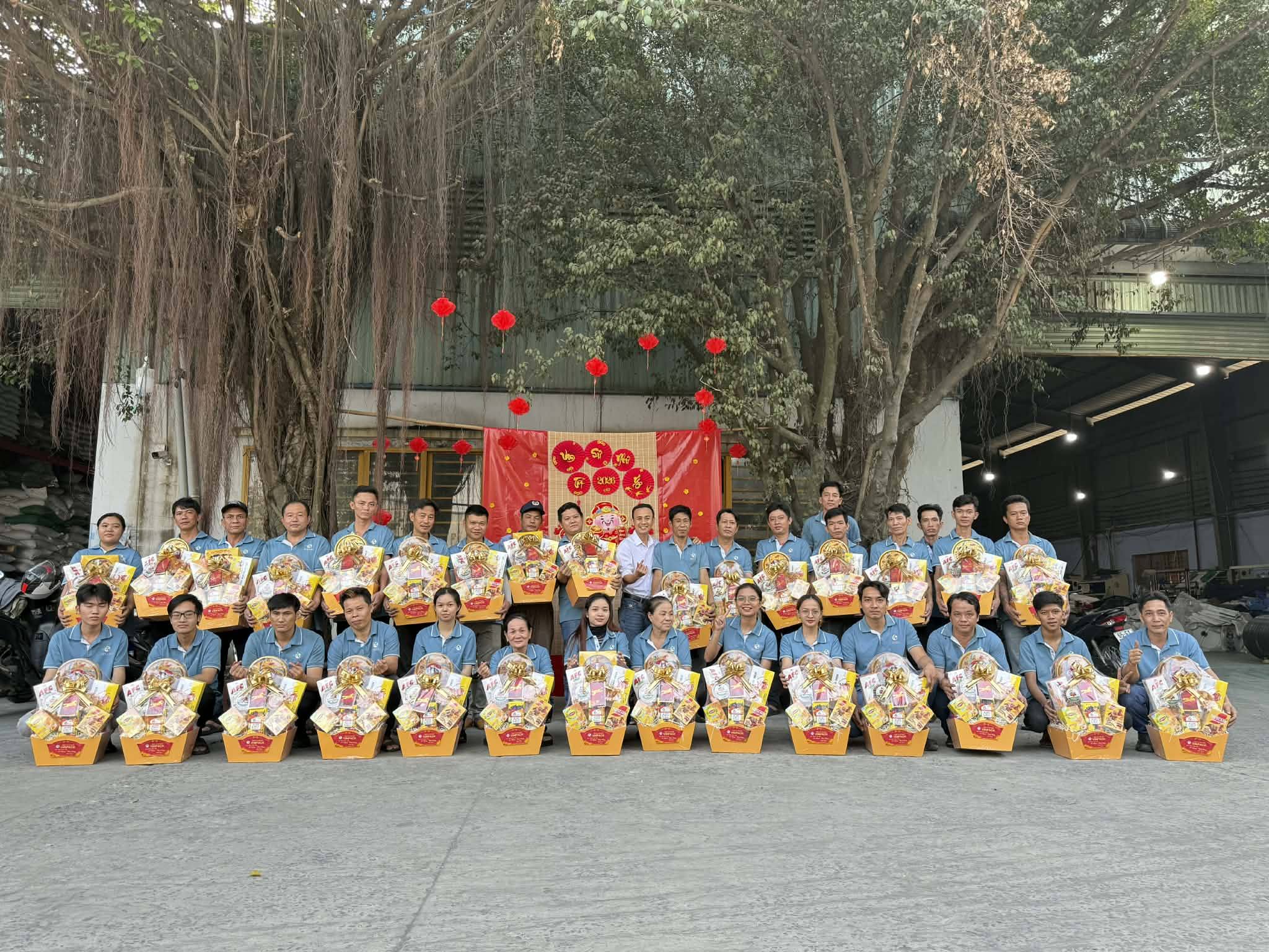 Tập thể công nhân nhà máy Vinpack cầm giỏ quà Tết chụp ảnh ngoài sân